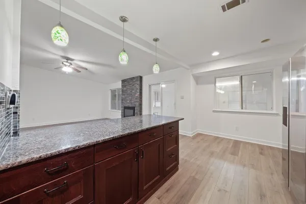 a kitchen with stainless steel appliances kitchen island granite countertop a large counter top and wooden floors