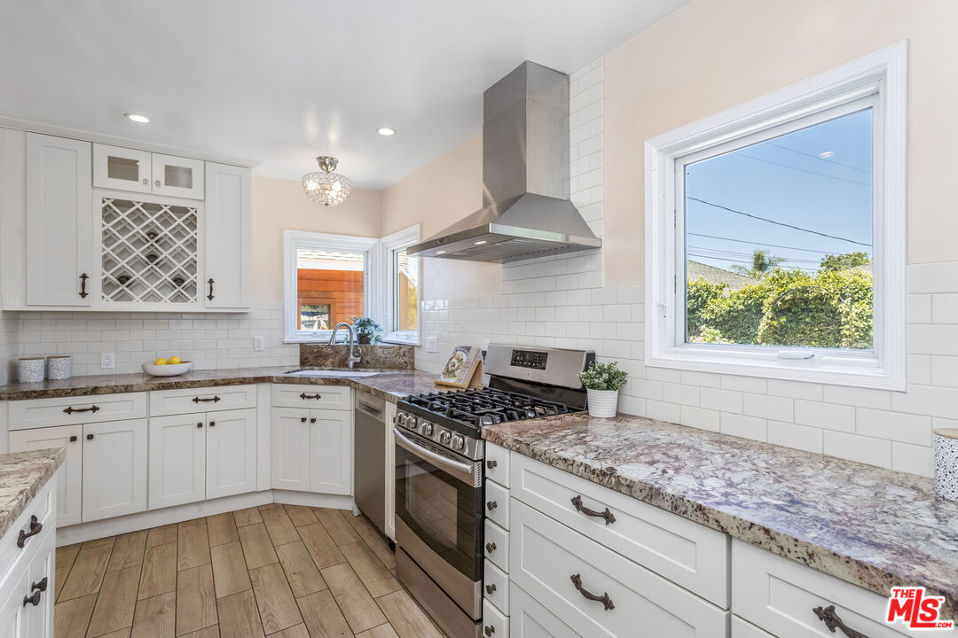 5967 Carpenter Avenue Valley Village, CA 91601 - Photo 11 of 32 a kitchen with stainless steel appliances granite countertop a stove a sink and a microwave