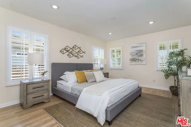 a bedroom with a large bed and a potted plant