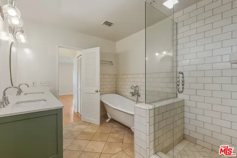 a bathroom with a sink a toilet a mirror and shower