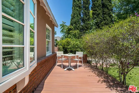 a patio with table and chairs and potted plants