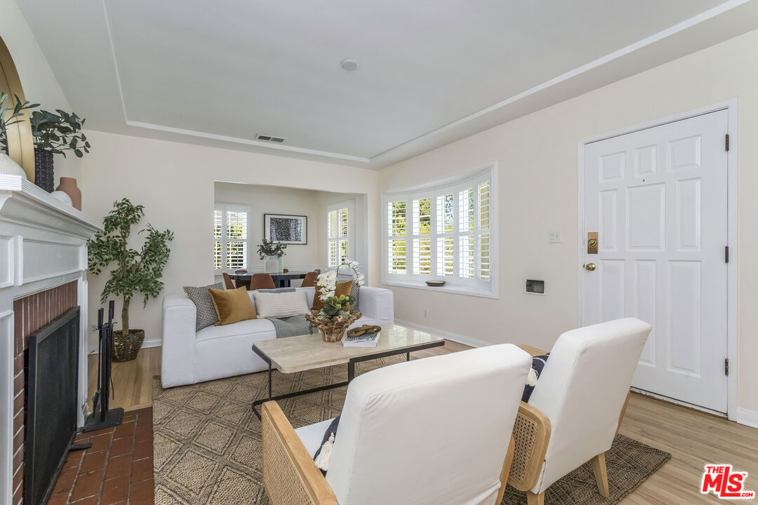 5967 Carpenter Avenue Valley Village, CA 91601 - Photo 8 of 32 a living room with furniture a fireplace and a potted plant