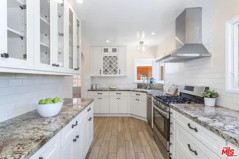 a kitchen with stainless steel appliances granite countertop a sink stove and cabinets
