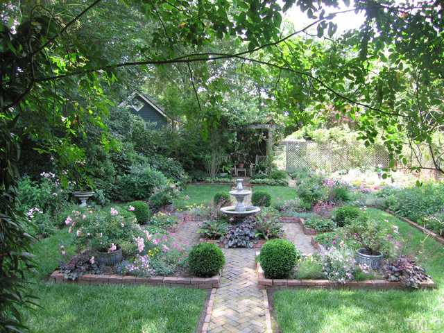 115 North Bloodworth Street Raleigh, NC 27601 - Photo 13 of 25 A four square garden with a recirculating two-tier fountain is the focal point as you enter the garden from the back porch. Herringbone brick paths lead to a wisteria and rose covered pergola beyond.