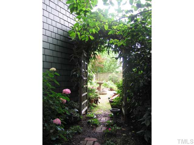 115 North Bloodworth Street Raleigh, NC 27601 - Photo 17 of 25 Brick paths lead through vine veiled trellises alongside the main house and the garden cottage.