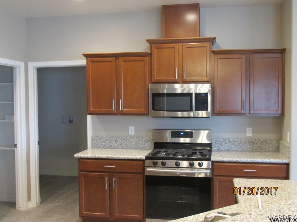 4276 East Cane Ranch Road Kingman, AZ 86401 - Photo 4 of 23 a kitchen with stainless steel appliances granite countertop a stove and a microwave