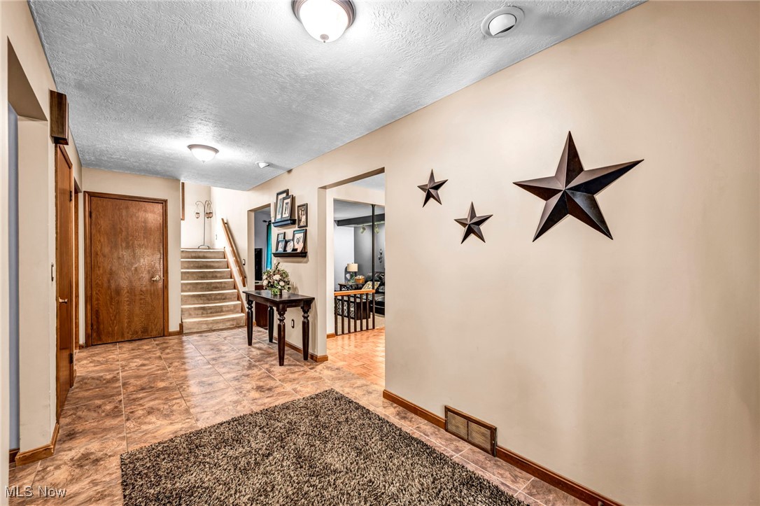 12938 Carter Road Painesville, OH 44077 - Photo 25 of 50 Hall featuring a textured ceiling and stairs