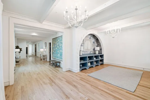 a bedroom with a large bed and a chandelier