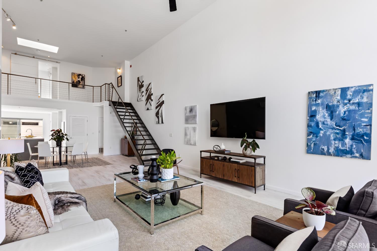 229 8th Street, Unit 3 San Francisco, CA 94103 - Photo 6 of 6 a living room with furniture and a flat screen tv