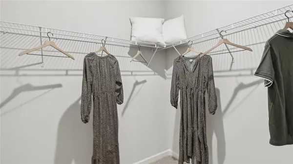 a view of walk in closet with clothes and shoes