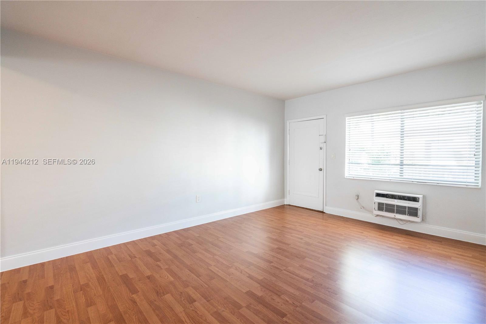 7315 Harding Avenue, Unit 16 Miami Beach, FL 33141 - Photo 2 of 13 an empty room with wooden floor and windows
