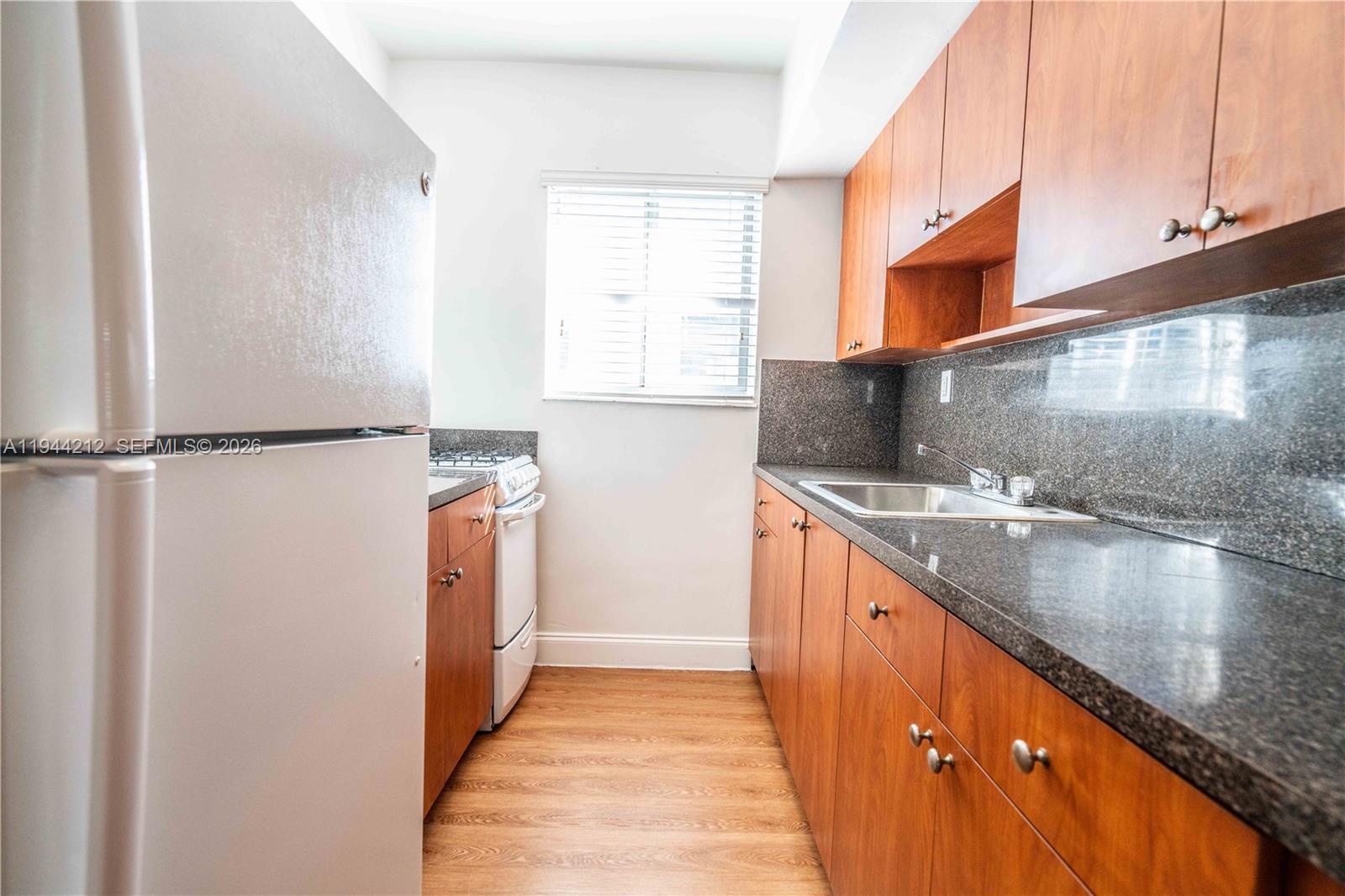 7315 Harding Avenue, Unit 16 Miami Beach, FL 33141 - Photo 8 of 13 a kitchen with stainless steel appliances granite countertop a sink and a stove
