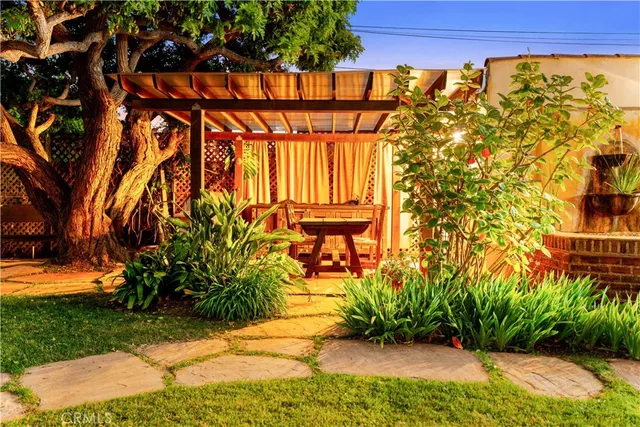 a view of a street with potted plants and large trees