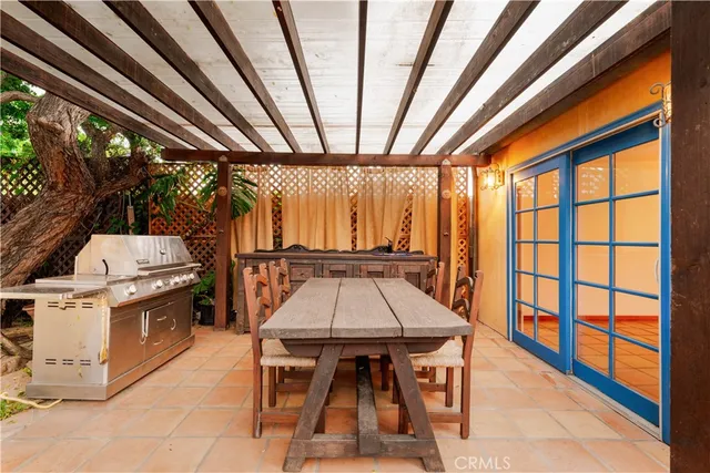a view of a patio with table and chairs a barbeque with wooden floor and roof