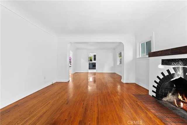 a view of empty room with wooden floor and fireplace
