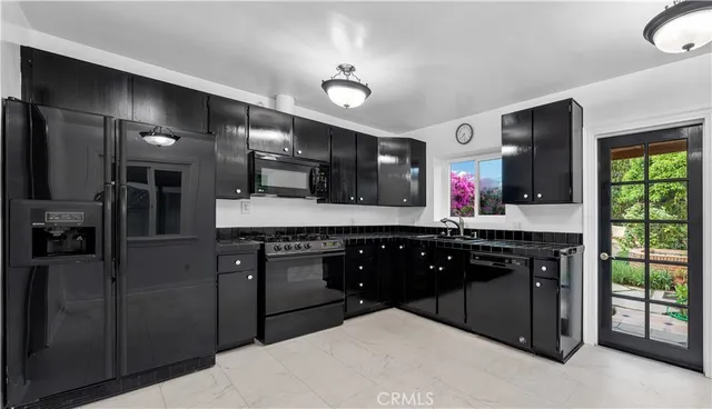 a kitchen with stainless steel appliances granite countertop a sink refrigerator and cabinets