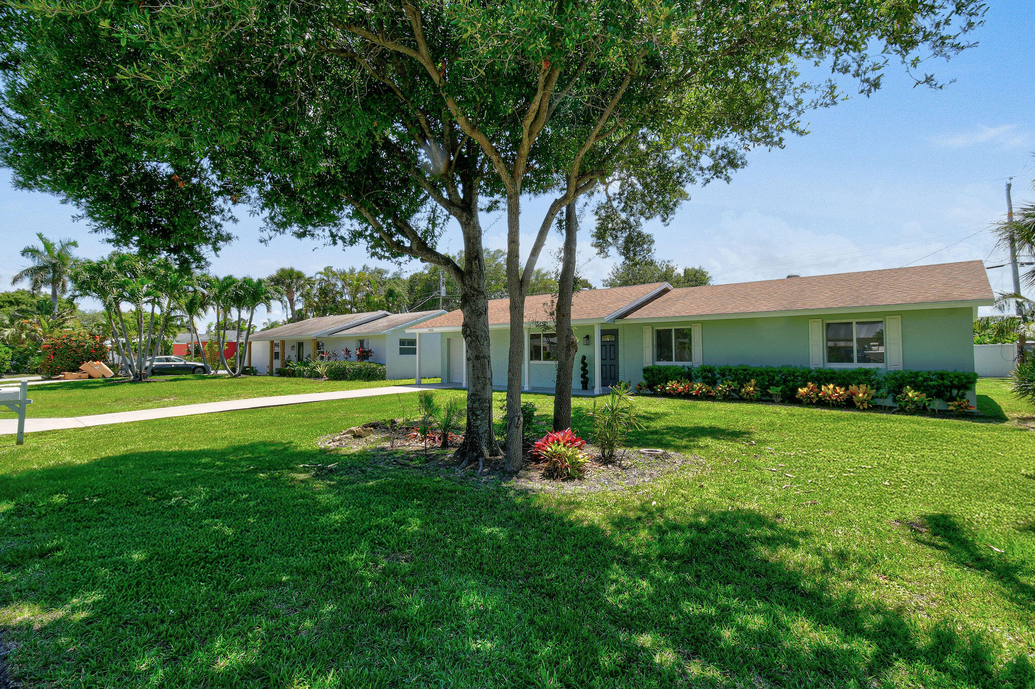 1522 Lance Road Jupiter, FL 33469 - Photo 1 of 50 a front view of a house with garden