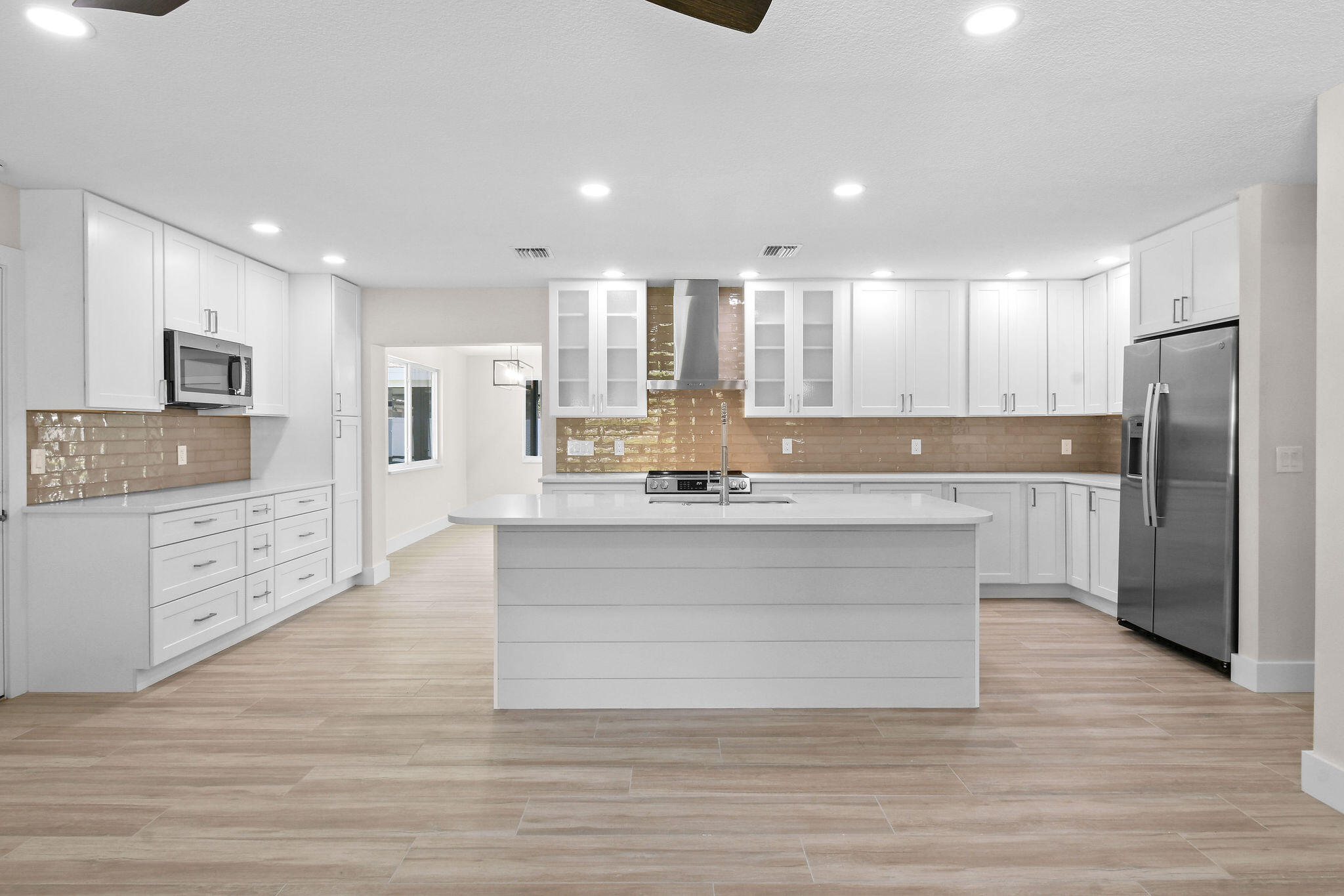 1522 Lance Road Jupiter, FL 33469 - Photo 11 of 50 a large kitchen with kitchen island a sink stainless steel appliances and cabinets