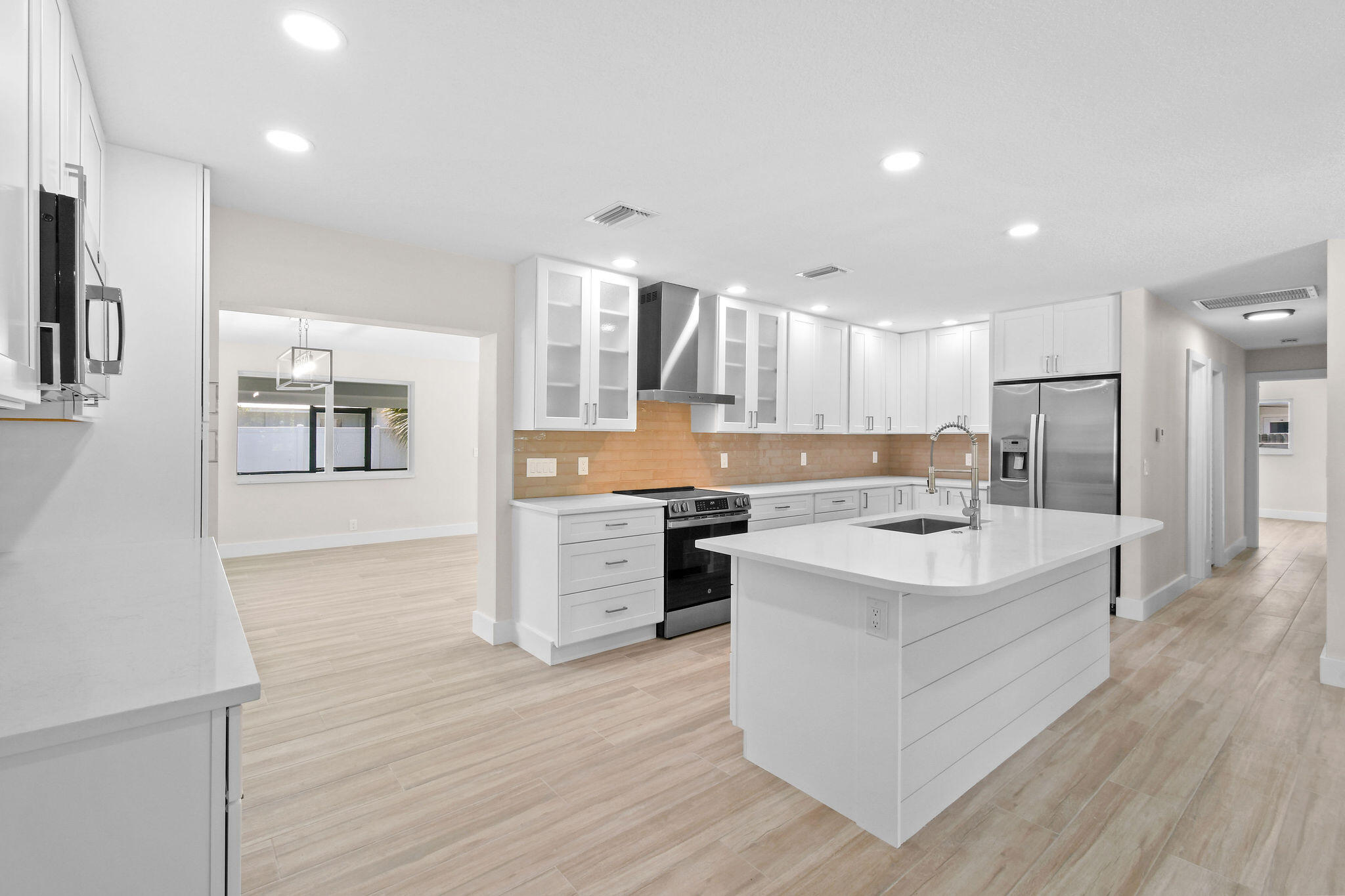 1522 Lance Road Jupiter, FL 33469 - Photo 12 of 50 a large kitchen with a center island wooden floor and stainless steel appliances