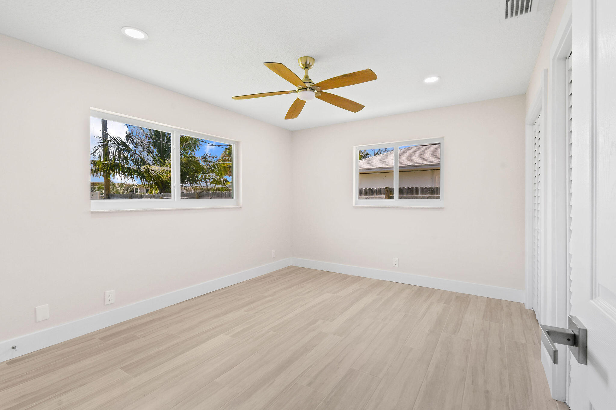 1522 Lance Road Jupiter, FL 33469 - Photo 19 of 50 an empty room with wooden floor ceiling fan and windows