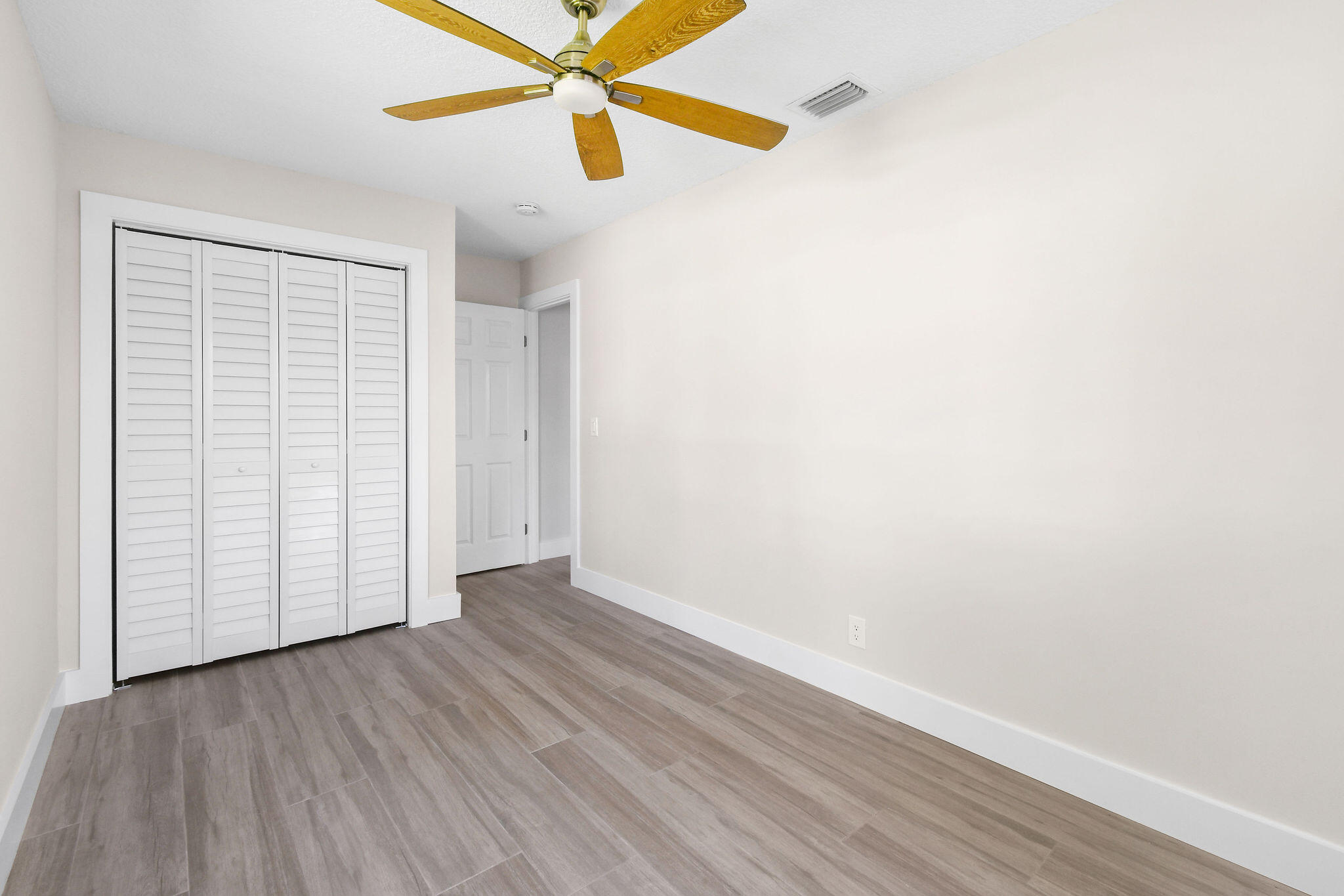 1522 Lance Road Jupiter, FL 33469 - Photo 28 of 50 an empty room with wooden floor closet and windows