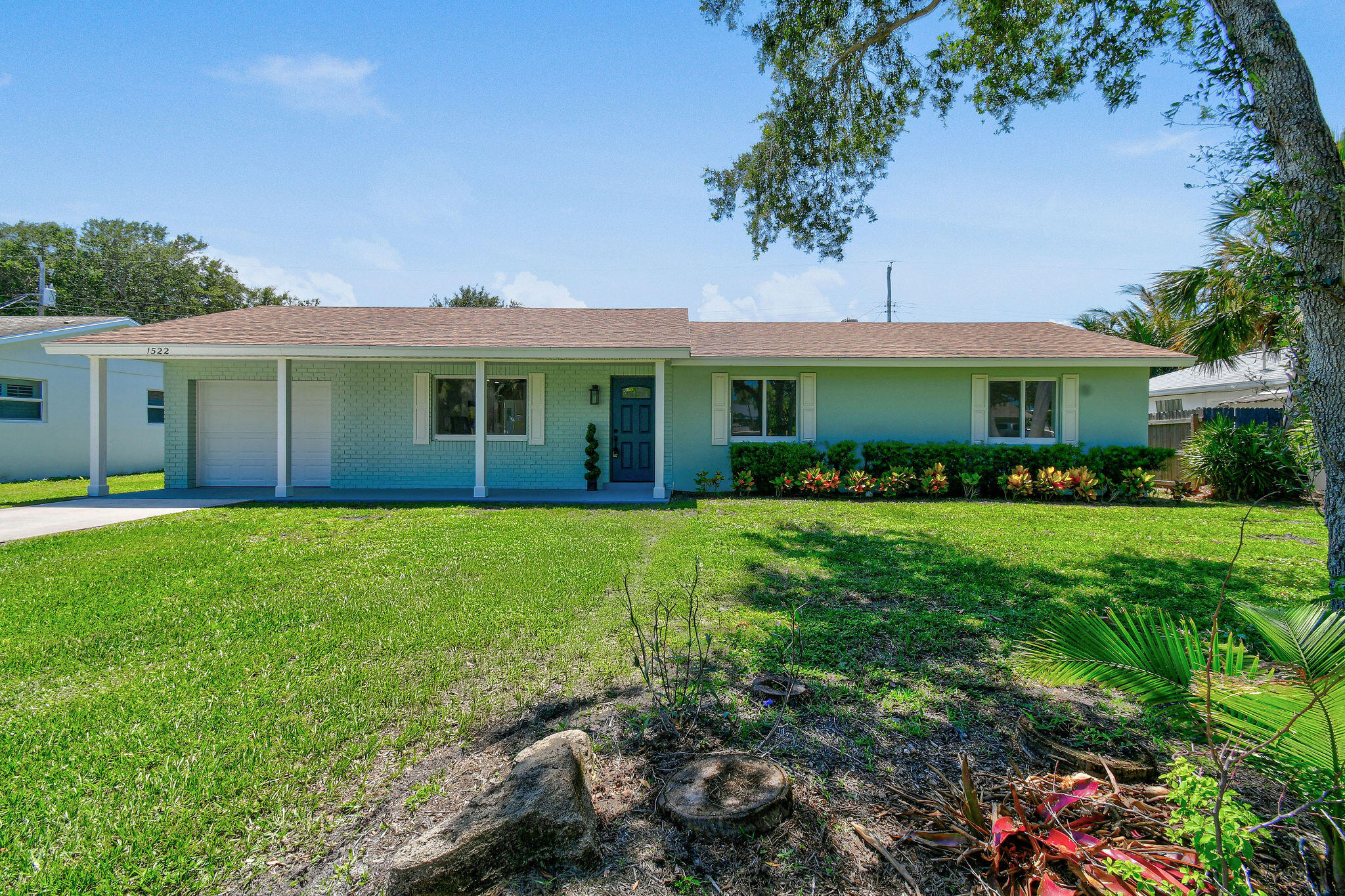 1522 Lance Road Jupiter, FL 33469 - Photo 4 of 50 a front view of a house with a garden and plants