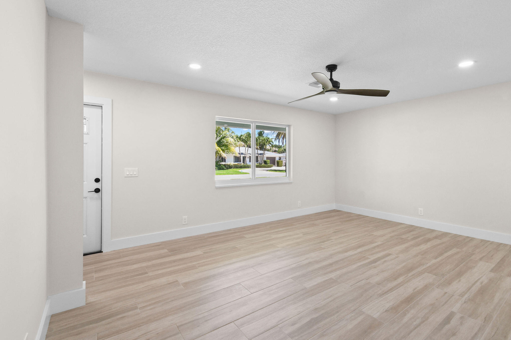 1522 Lance Road Jupiter, FL 33469 - Photo 10 of 50 an empty room with wooden floor ceiling fan and windows