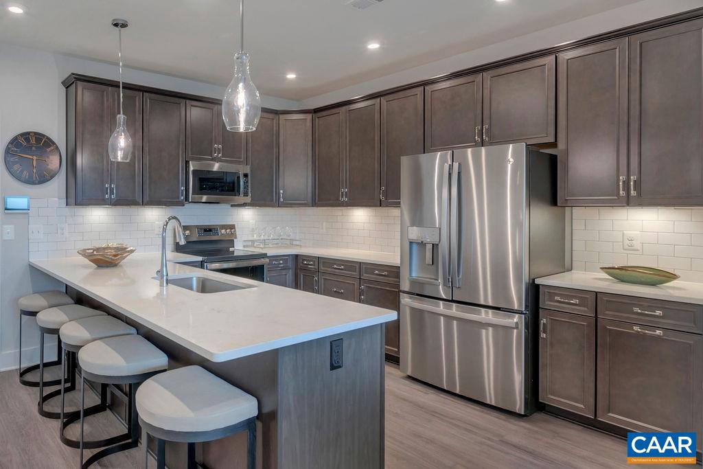 809 Wesley Lane, Unit A Charlottesville, VA 22911 - Photo 7 of 18 a kitchen with kitchen island a wooden floor and stainless steel appliances