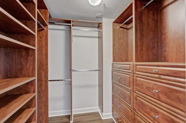 a view of walk in closet with empty racks