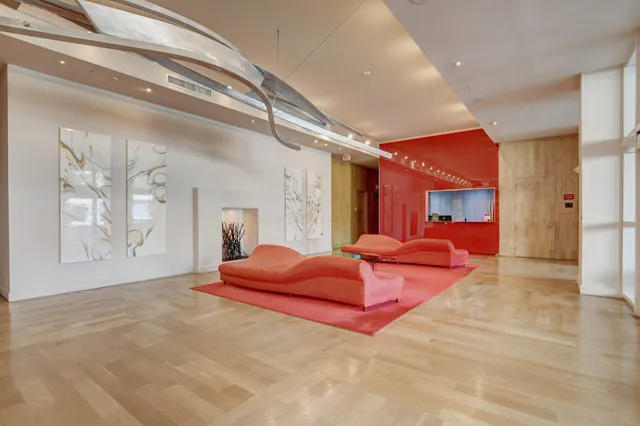 a spacious bedroom with a large bed and a chandelier