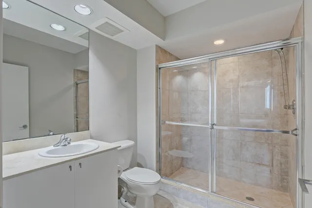 a bathroom with a shower sink vanity and toilet