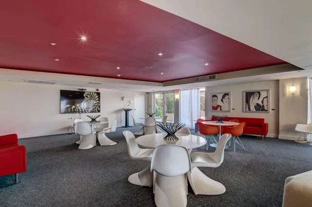 a living room with furniture a table and a painting on the wall