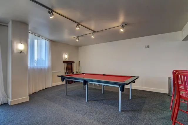 a room with furniture pool table and a window