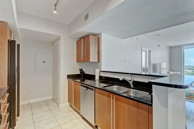 a kitchen with granite countertop a sink and cabinets