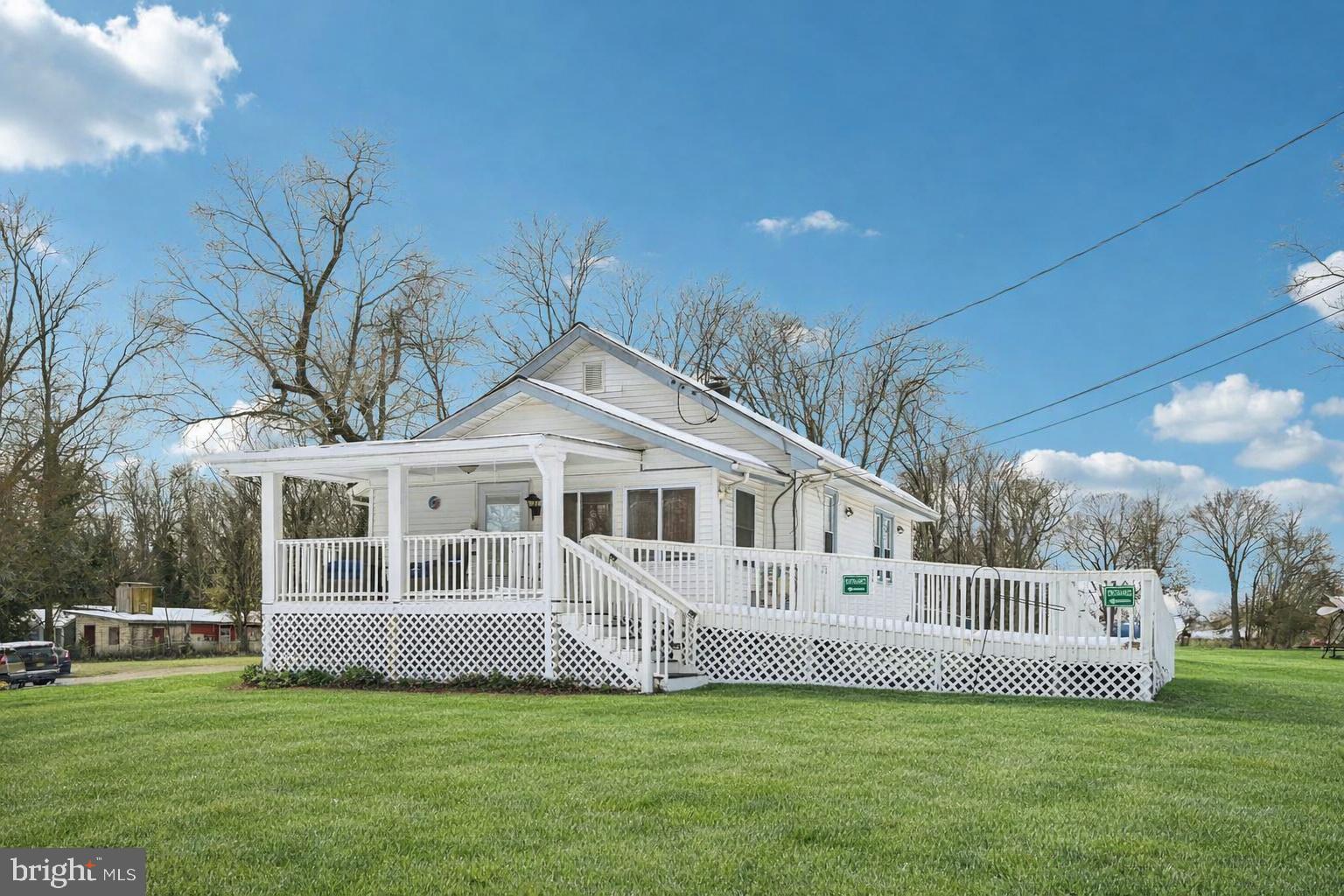 a view of a house with a big yard and large trees