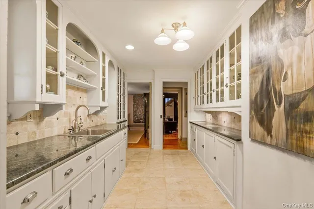 a large white kitchen with granite countertop a sink and dishwasher