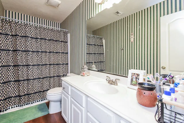 a bathroom with a sink toilet and shower
