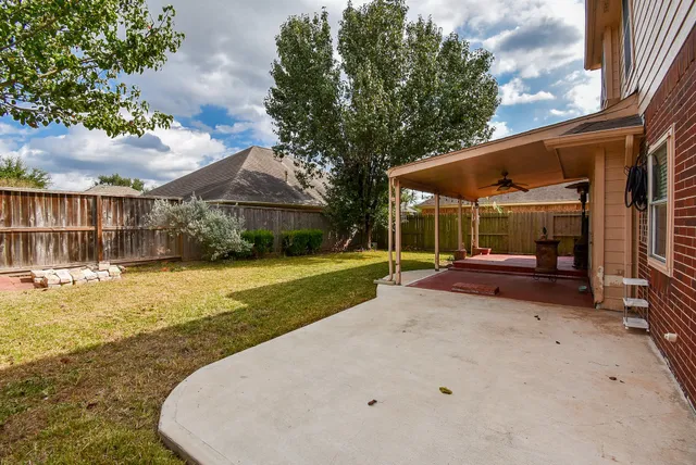 a view of a house with backyard and sitting area