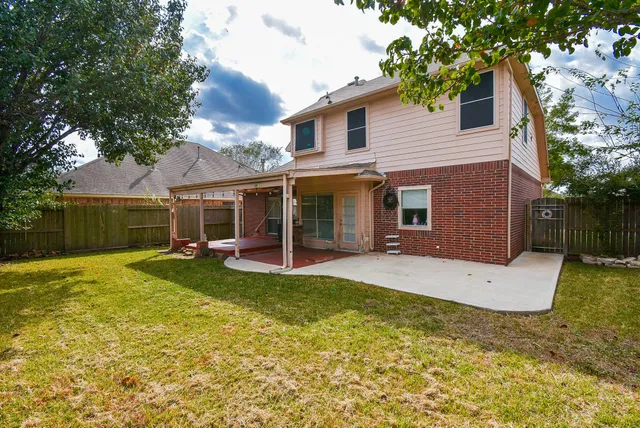 a view of a house with a patio and a yard