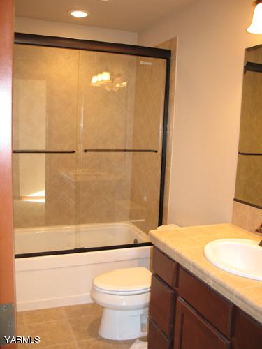 8990 Coolidge Road, Unit 7 Yakima, WA 98903 - Photo 12 of 15 a bathroom with a granite countertop sink toilet and shower