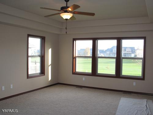 8990 Coolidge Road, Unit 7 Yakima, WA 98903 - Photo 8 of 15 a view of an empty room with a window and chandelier fan