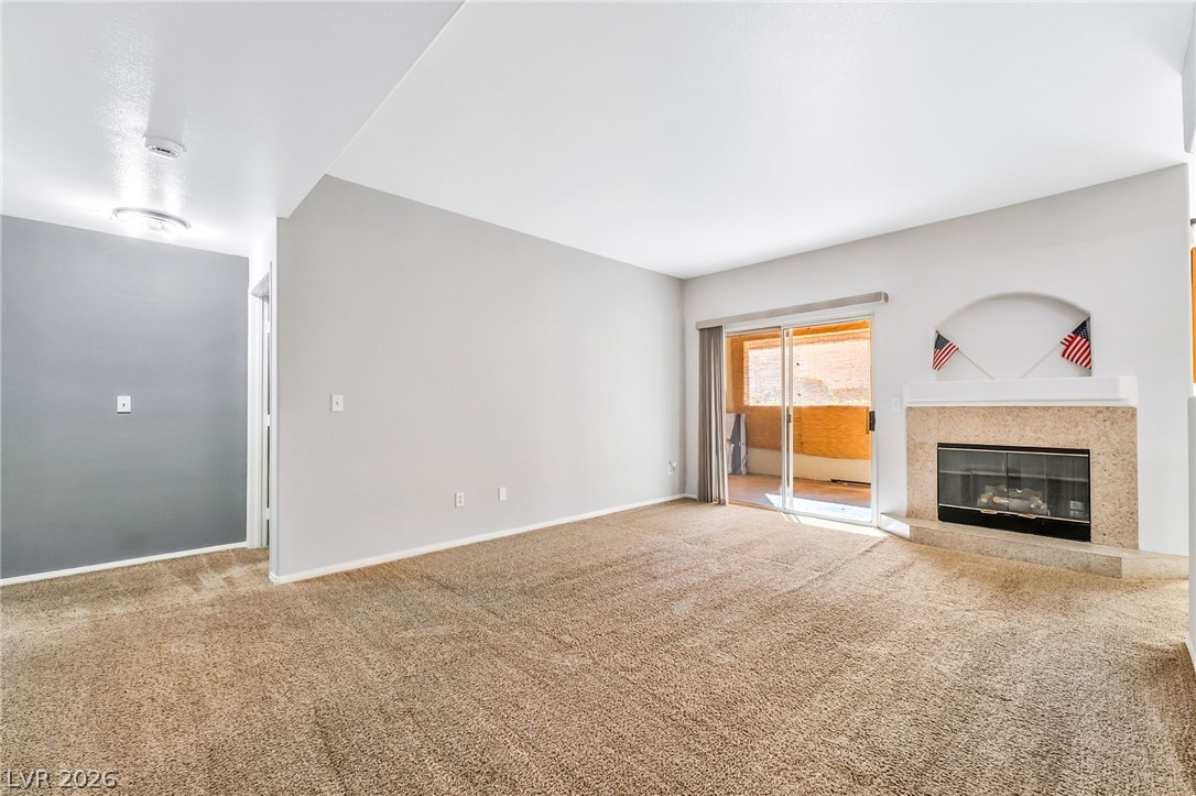 2050 West Warm Springs Road, Unit 2411 Henderson, NV 89014 - Photo 6 of 37 Cozy living space featuring a inviting fireplace and access to an outdoor area.