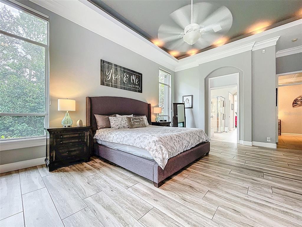 414 Westgate Road Tarpon Springs, FL 34688 - Photo 16 of 75 a bedroom with a large bed and a chandelier