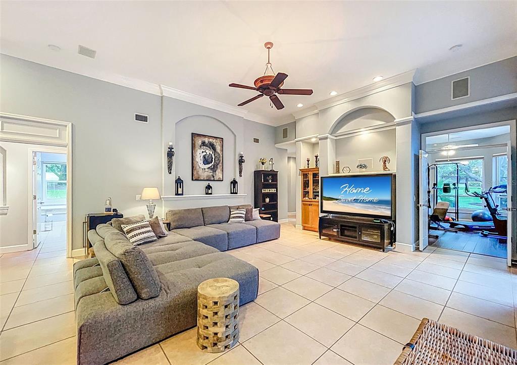 414 Westgate Road Tarpon Springs, FL 34688 - Photo 27 of 75 a living room with furniture a flat screen tv and a fireplace