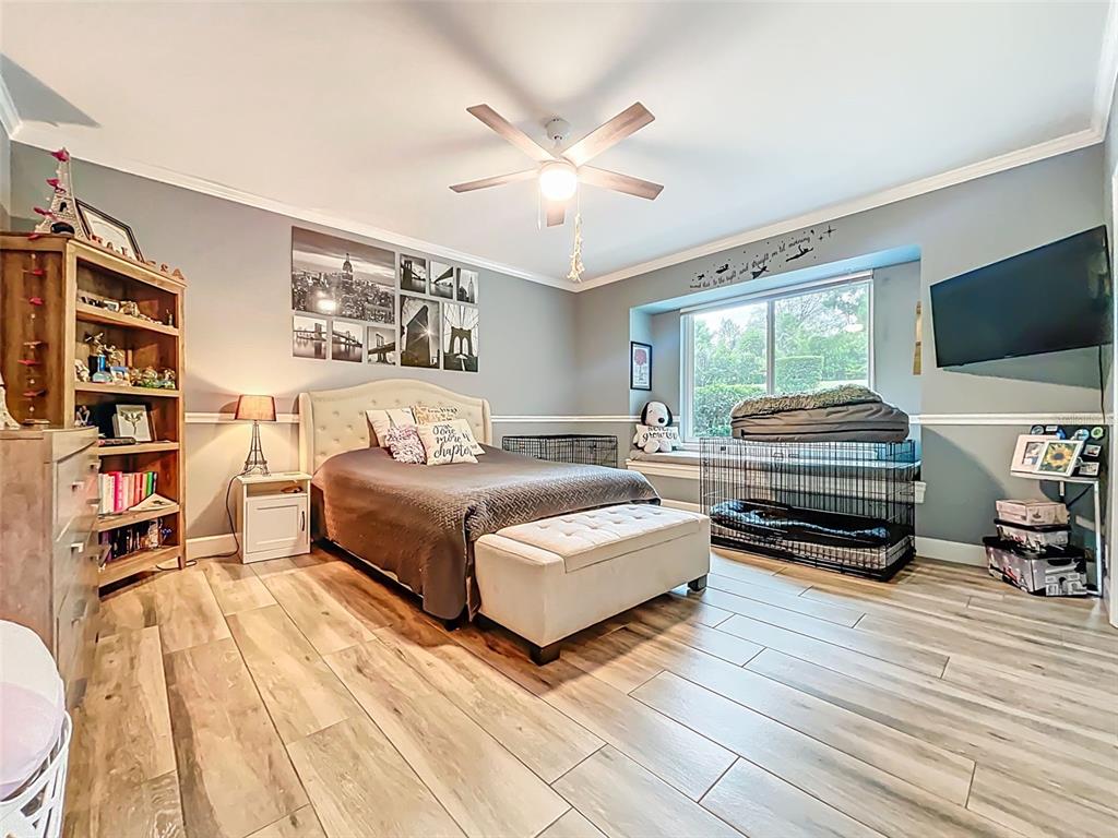 414 Westgate Road Tarpon Springs, FL 34688 - Photo 31 of 75 a bedroom with a bed and a chandelier