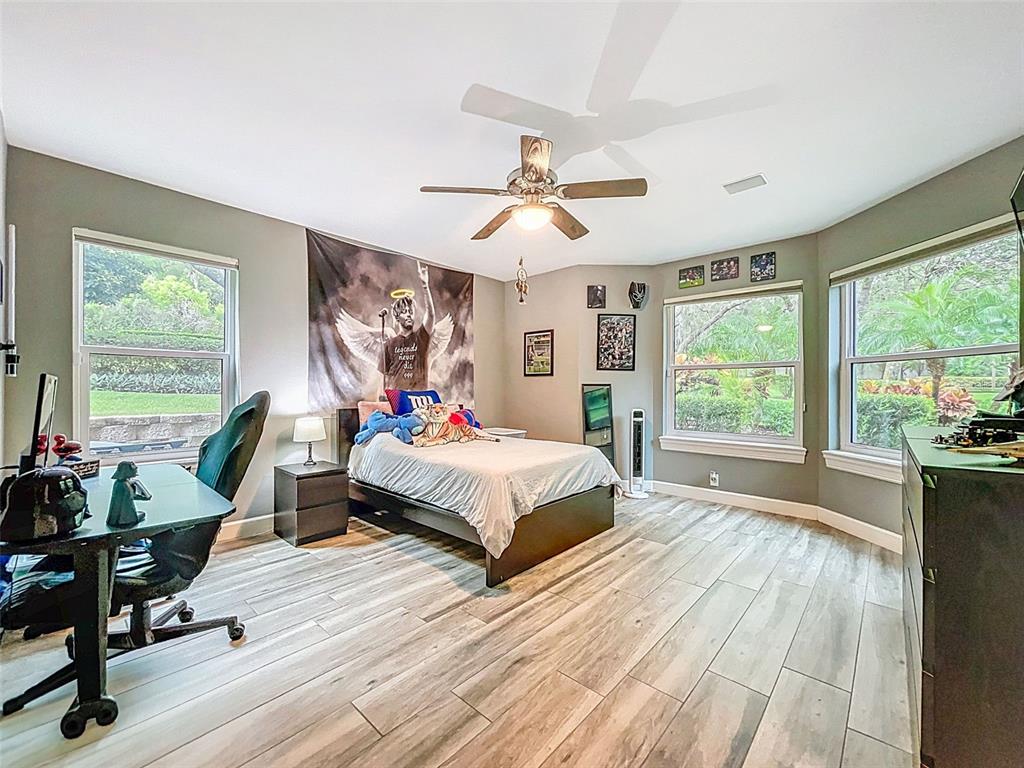 414 Westgate Road Tarpon Springs, FL 34688 - Photo 42 of 75 a spacious bedroom with a bed a large window and walk in closet