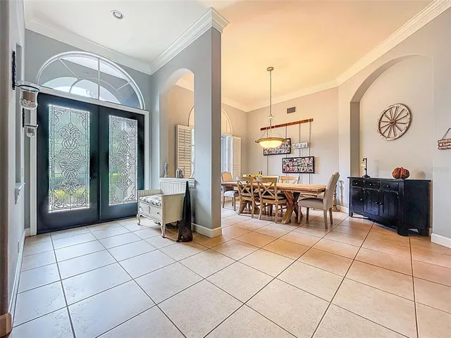 a view of a dining room and livingroom with furniture wooden floor a rug a painting and a chandelier