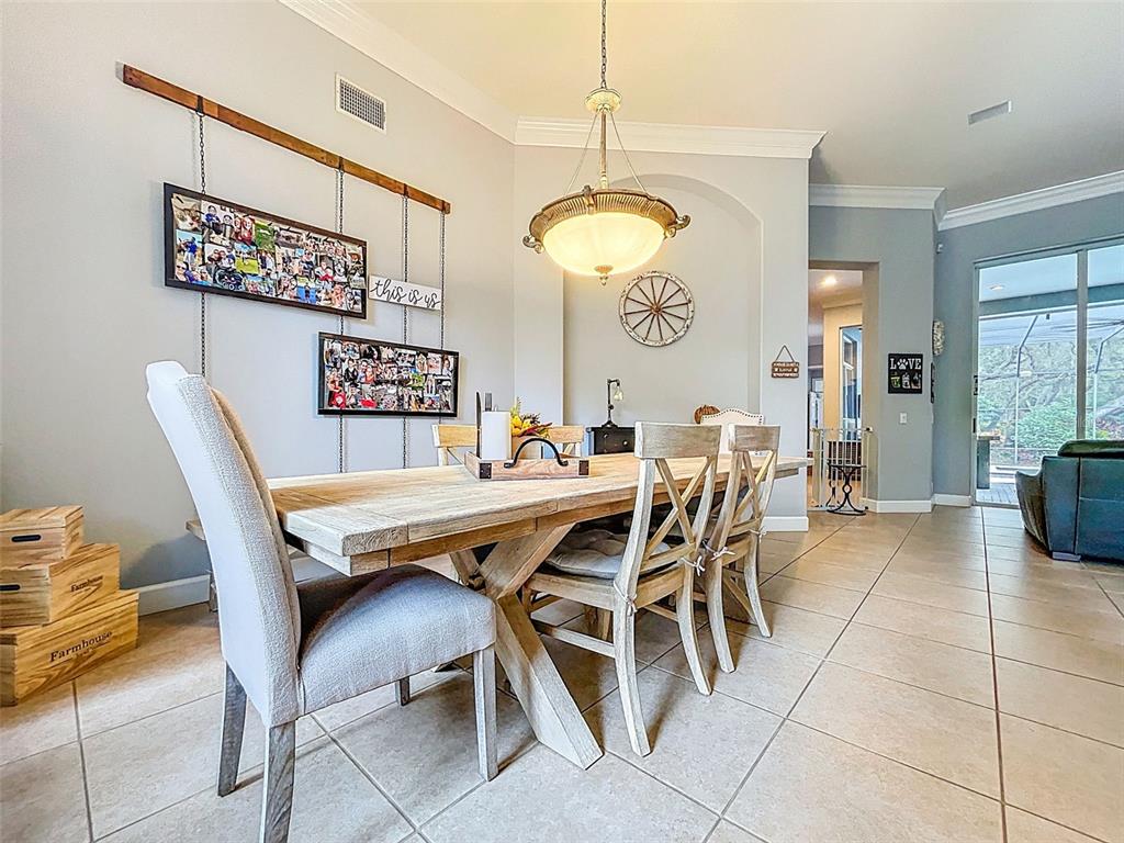414 Westgate Road Tarpon Springs, FL 34688 - Photo 9 of 75 a dining room with a wooden table and chairs