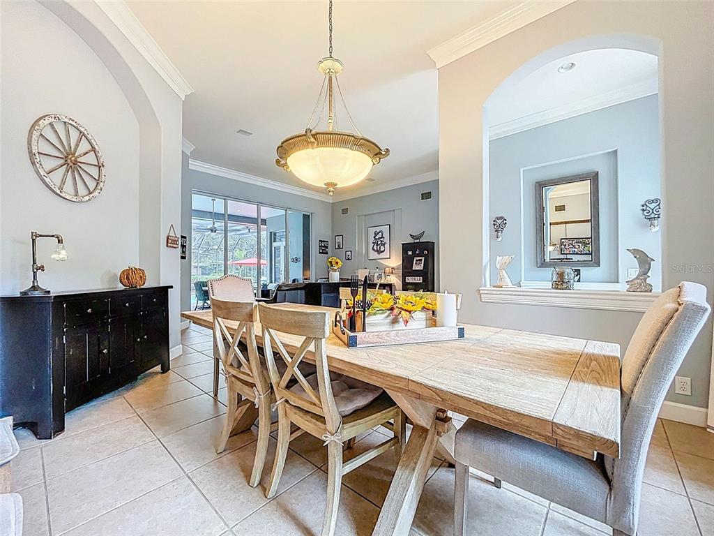 414 Westgate Road Tarpon Springs, FL 34688 - Photo 10 of 75 a view of a dining room and livingroom with furniture wooden floor a rug a painting and a chandelier