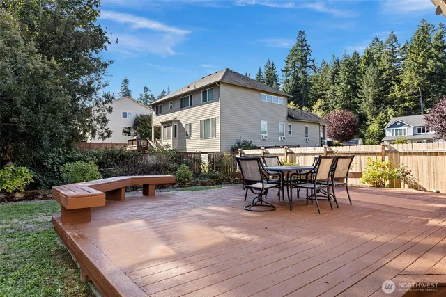 a view of a patio with table and chairs with wooden floor and fence